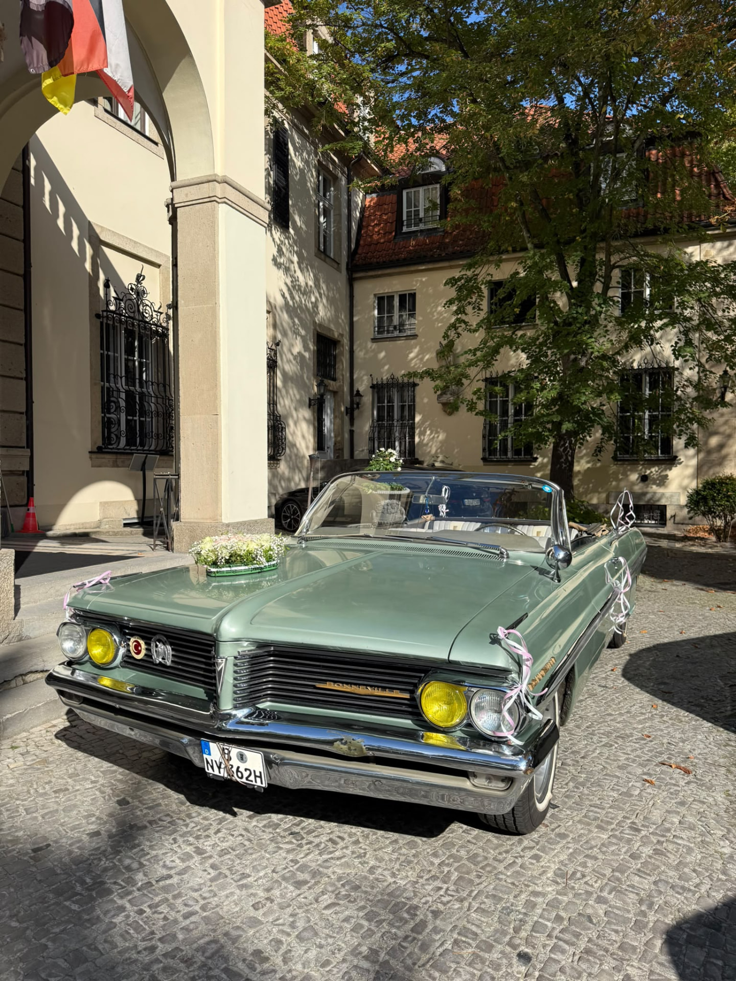 Pontiac Bonneville Cabriolet mit Blumenschmuck vor einer Location
